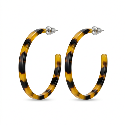 Para żółto-czarnych kolczyków z żywicy w kształcie otwartych kółek na białym tle